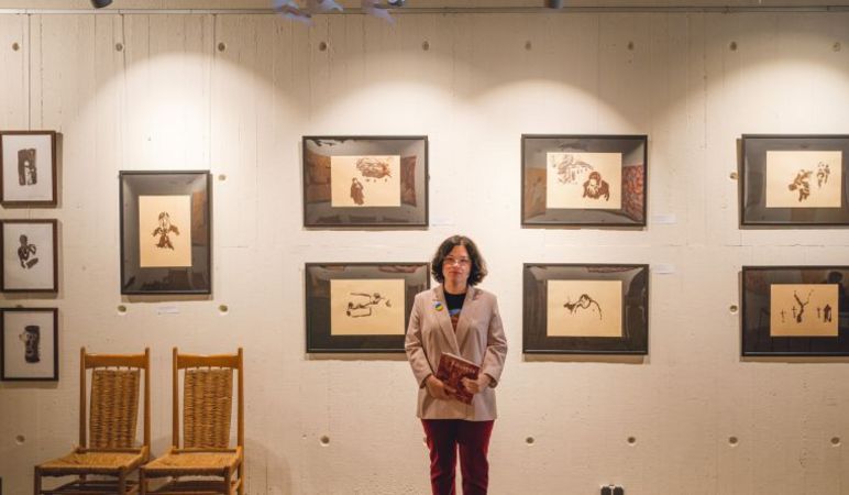 Die ukrainische Künstlerin Angela Kushchyk vor ihren Bildern, die in St. Nikolai ausgetellt werden.