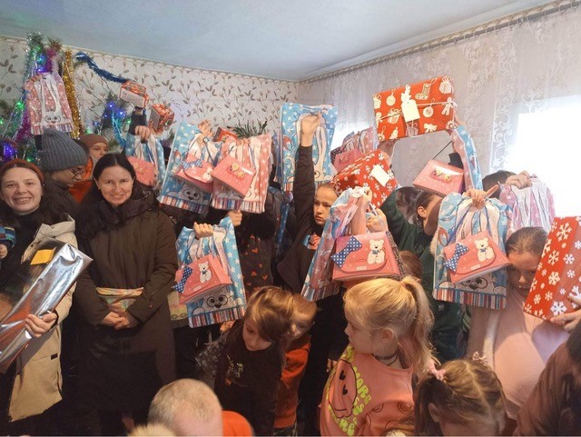 Junge Menschen in der Ukraine freuen sich um gespendete Pakete